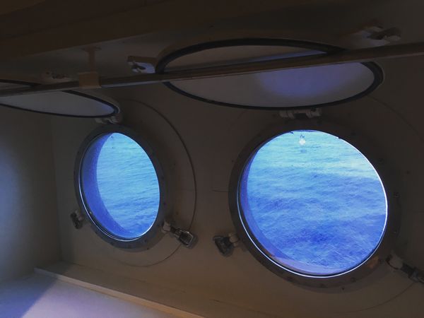 日本・久米島「にっぽん丸で沖縄離島」の写真：久米島到着。キャビンの円窓から外を見る。...