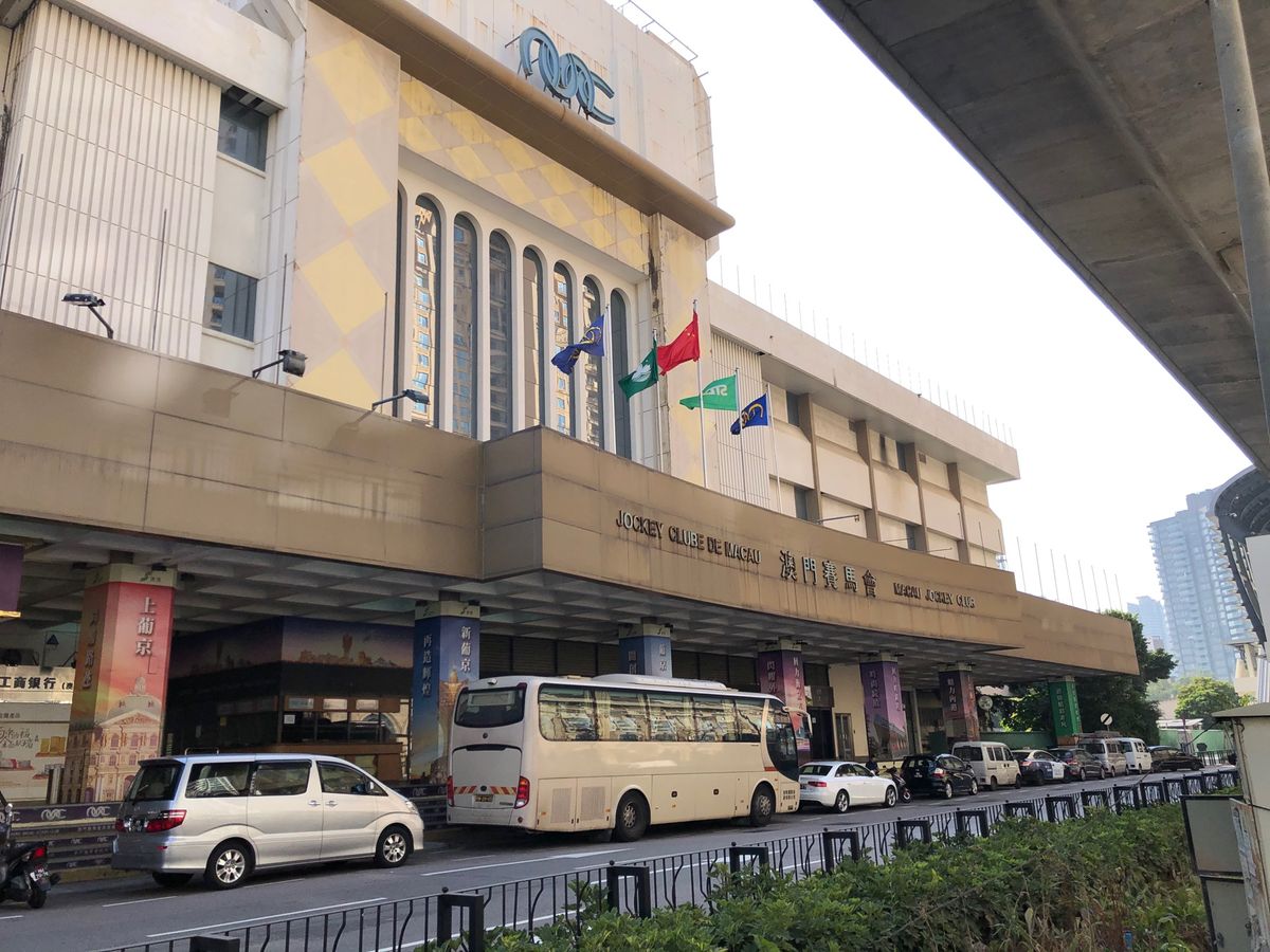 マカオ競馬場はかなりローカルな感じです。客席とコースの間には駐車場があった...