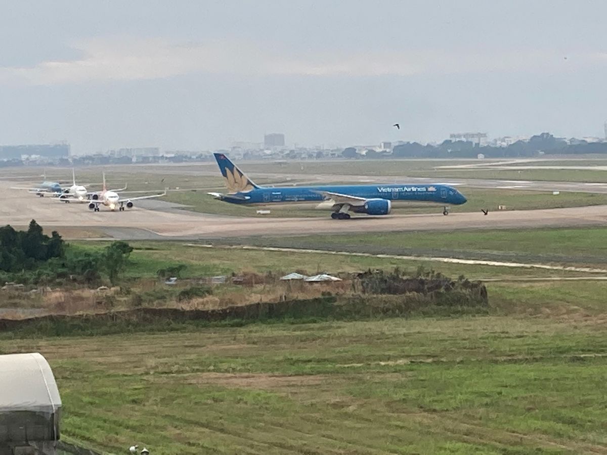 ホーチミン市タンソンニャット空港の飛行機の眺められるカフェに続き、飛行機の...