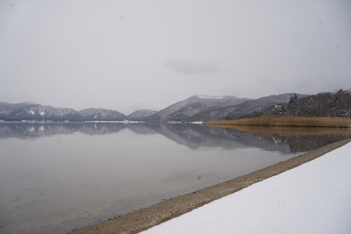 今日は雪が降っている田沢湖。
湖面に映る山が美しい。